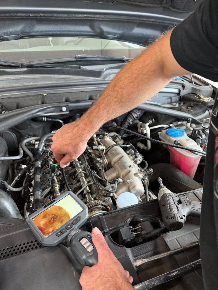 Trafton's technician running a DEPSTECH borescope into an Audi engine bay, live image on the handheld screen