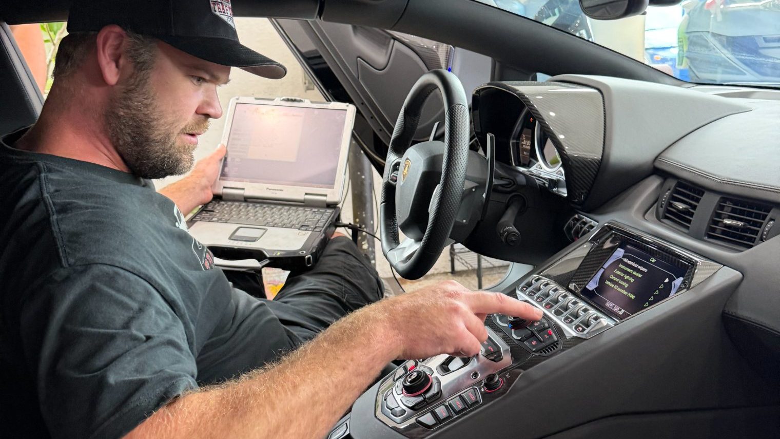 Trafton's technician running factory diagnostics on a Lamborghini Aventador with a ruggedized laptop