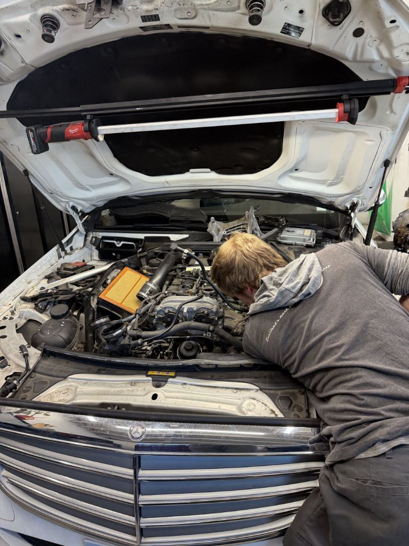 Trafton's technician working in the engine bay of a Mercedes-Benz sedan in Portland, Oregon