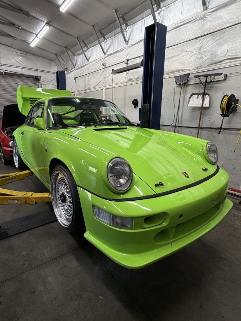Lime green Porsche 911 hot rod with whale tail on the lift at Trafton's Foreign Auto