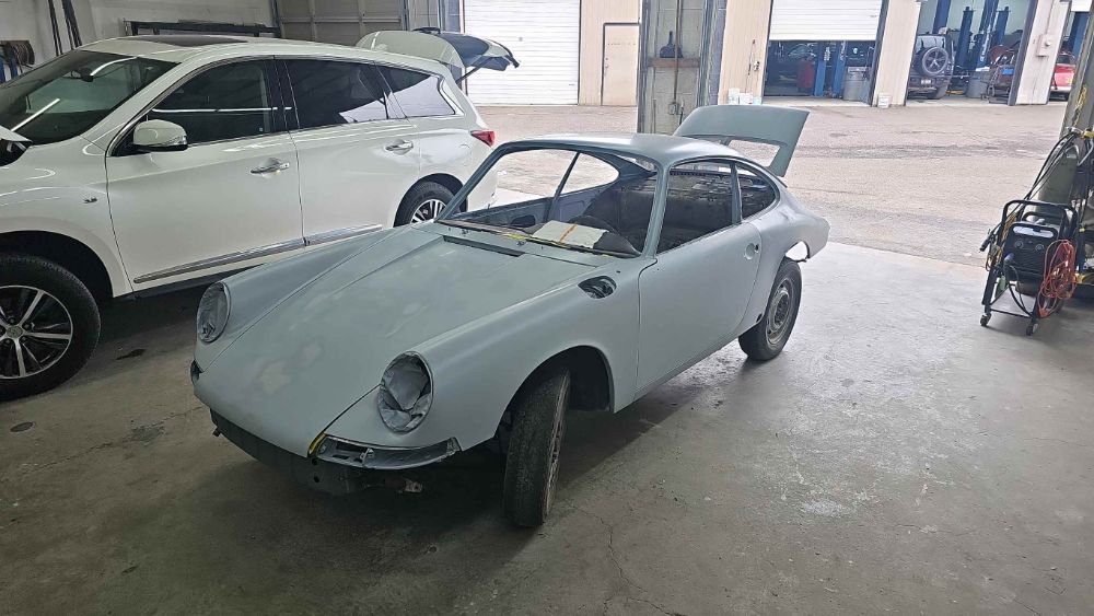 The restored 1966 Porsche 911 body straightened and laid in grey primer at Trafton's