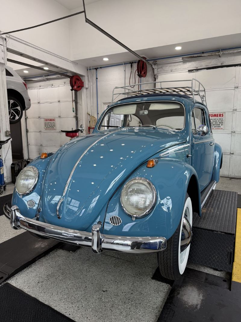 Restored blue Volkswagen Beetle with a roof rack in the service bay at Trafton's Foreign Auto