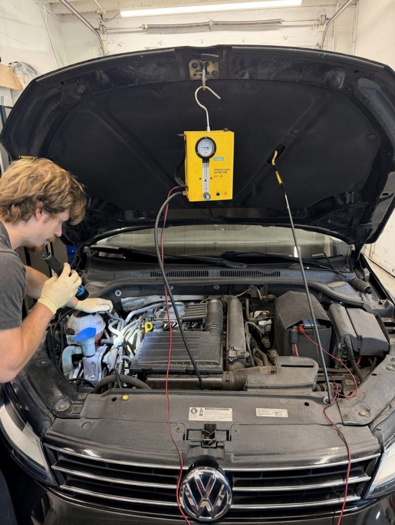 Smoke leak detector hooked up to a Volkswagen Jetta to find a vacuum leak